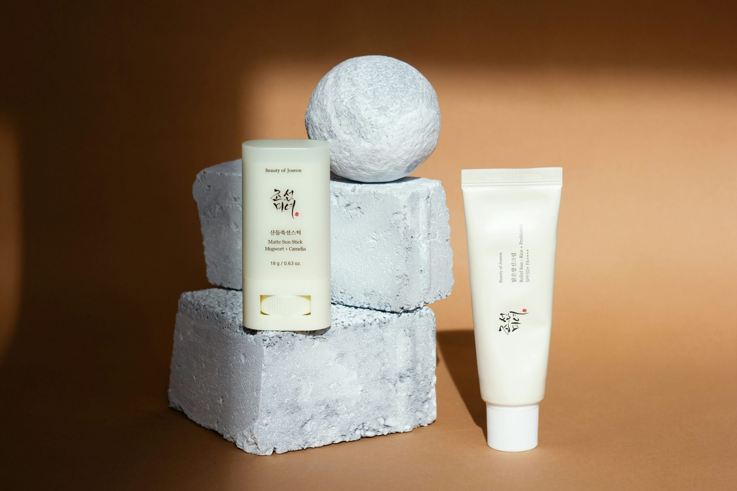 Korean sunscreen tube displayed on a stone surface in a natural light 