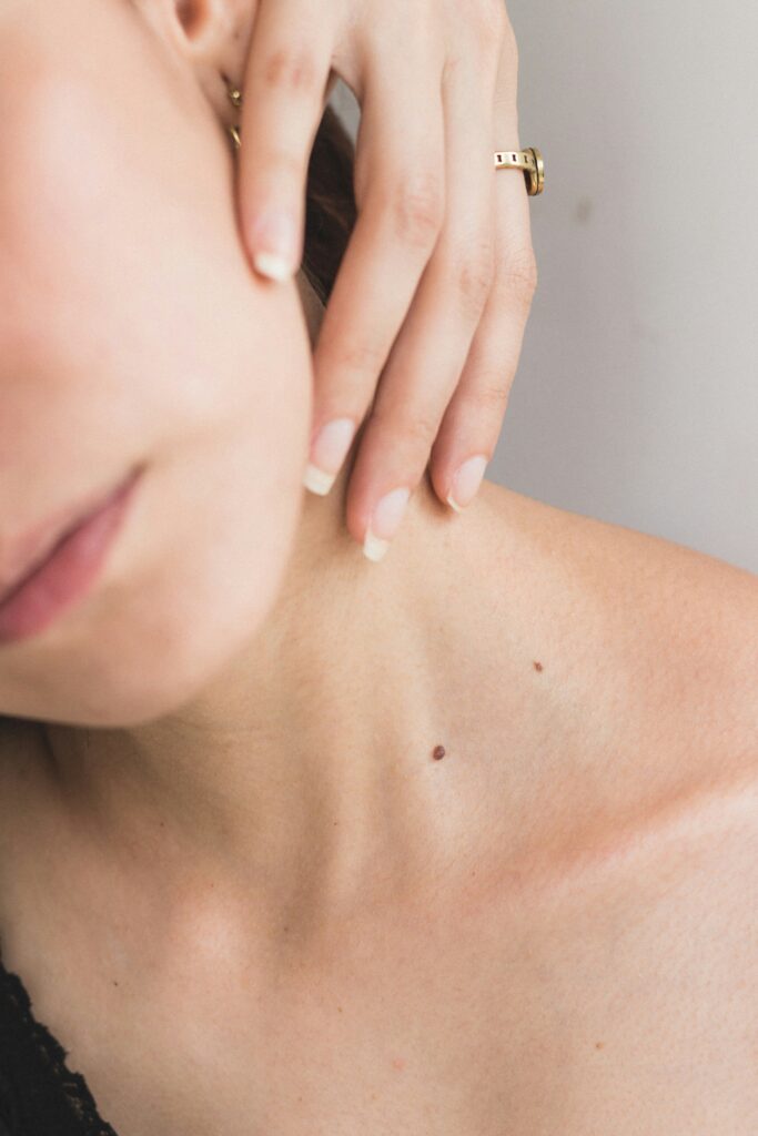 Close-up of natural skin on the neck and jawline in soft light, showing healthy skin texture and a calm skincare moment