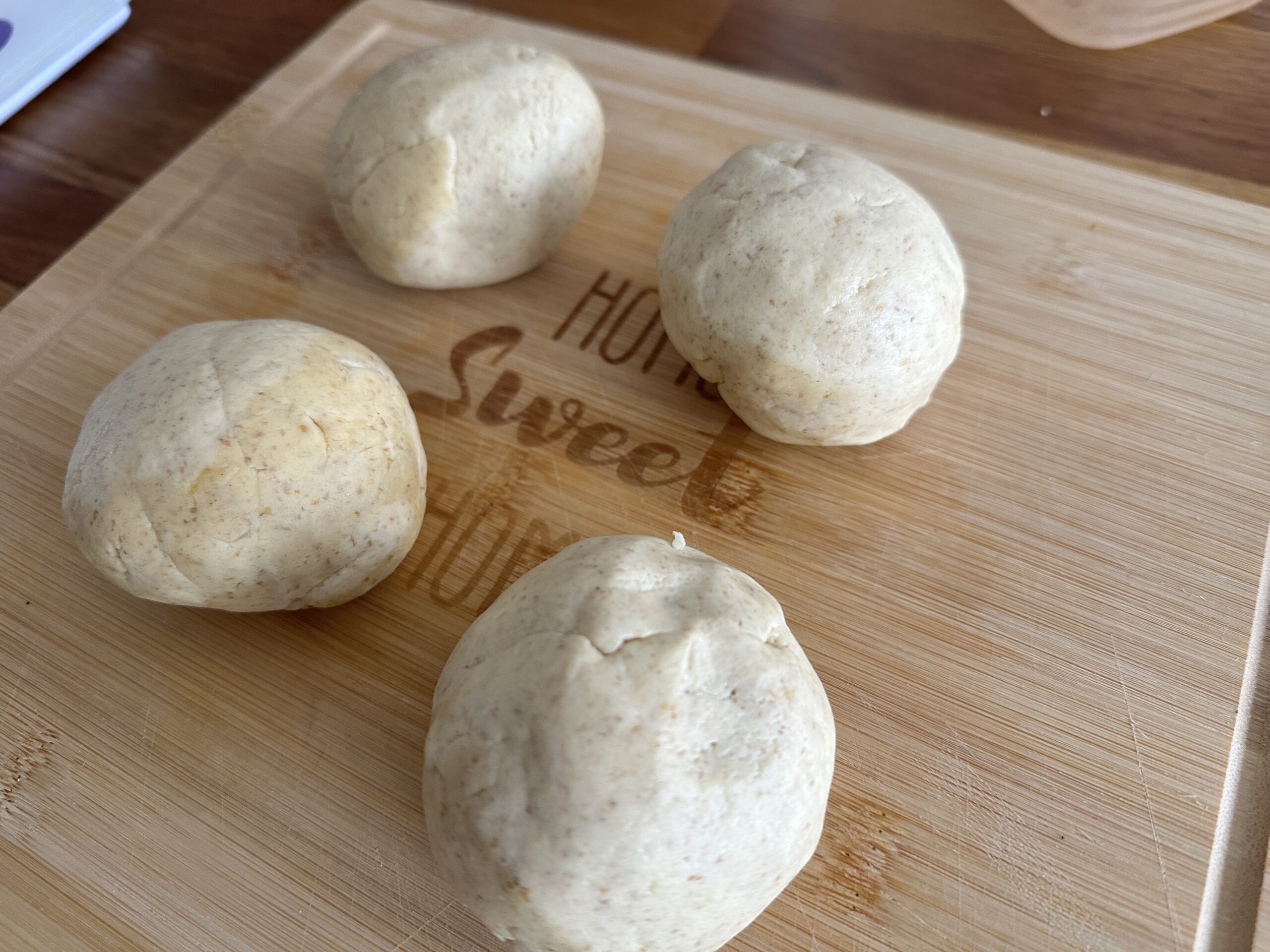 Divide the dough into 4 equal portions and shape them into balls.