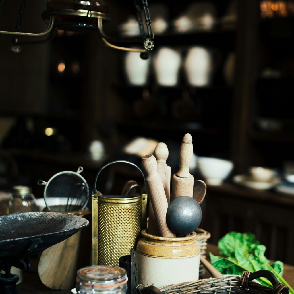 Cozy dark kitchen scene with rustic cooking tools, wooden utensils, and meal prep styling for a warm lifestyle blog aesthetic.